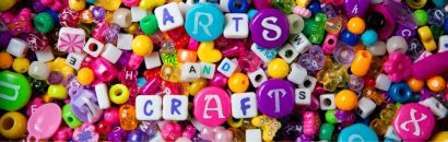 Colorful craft beads spelling out the words "Arts and Crafts"